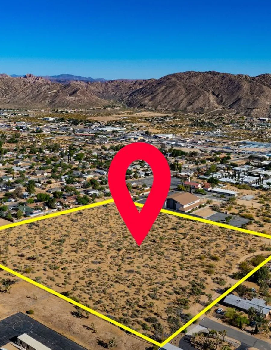 An aerial view of a marked-out residential plot on the edge of a town