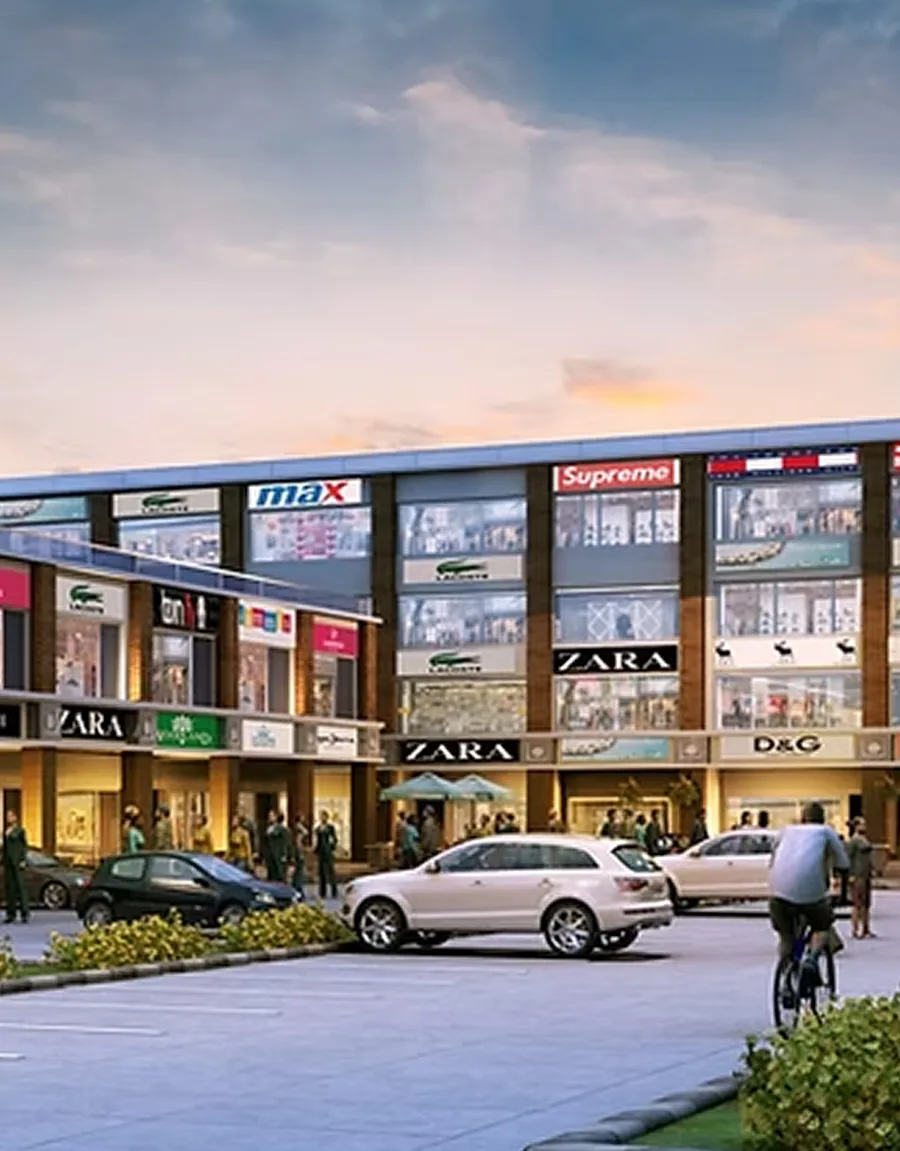 A row of lit retail showrooms at dusk with parking in front